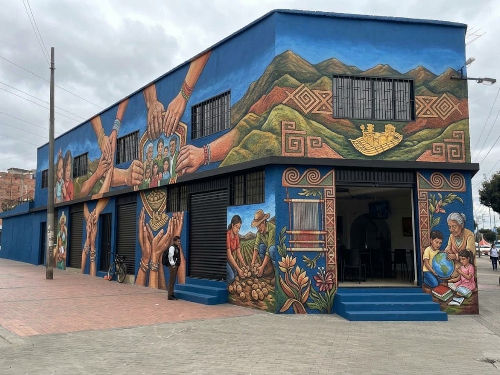 Sede de la Asociación Bujía en Soacha, con murales de familias, manos y tradiciones